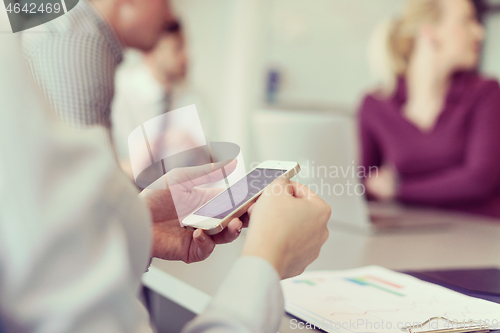 Image of close up of  busineswoman hands  using smart phone on meeting