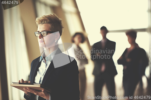 Image of business woman  at office with tablet  in front  as team leader