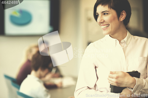 Image of hispanic businesswoman with tablet at meeting room