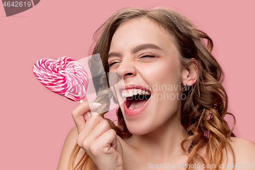 Image of beauty portrait of a cute girl in act to eat a candy