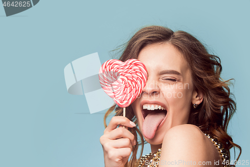 Image of beauty portrait of a cute girl in act to eat a candy