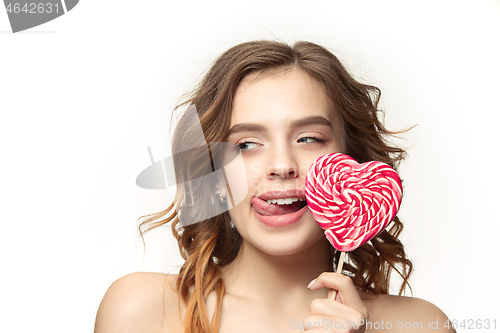 Image of beauty portrait of a cute girl in act to eat a candy