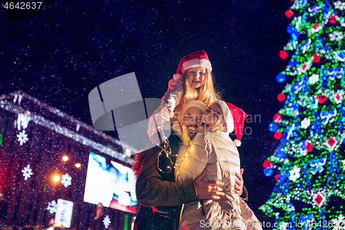 Image of family, christmas, holidays, season and people concept - happy family over city background and snow