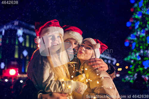 Image of family, christmas, holidays, season and people concept - happy family over city background and snow