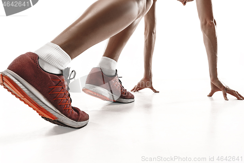 Image of Portrait of young sporty woman at starting block of race isolated over white background