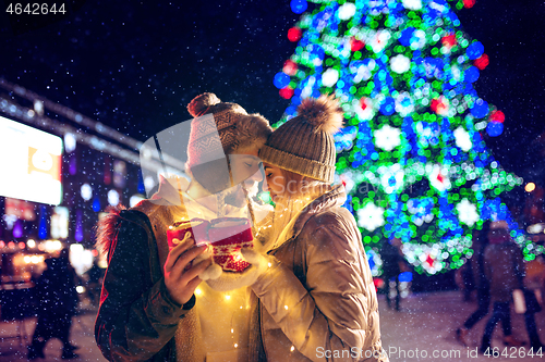 Image of Adult couple hanging out in the city during Christmas time