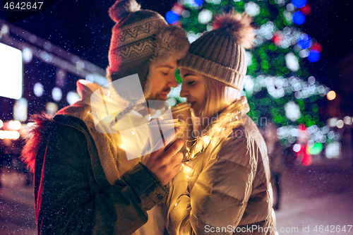 Image of Adult couple hanging out in the city during Christmas time