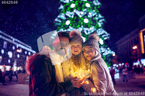 Image of family, christmas, holidays, season and people concept - happy family over city background and snow