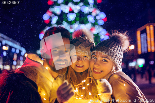 Image of family, christmas, holidays, season and people concept - happy family over city background and snow