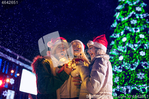 Image of family, christmas, holidays, season and people concept - happy family over city background and snow