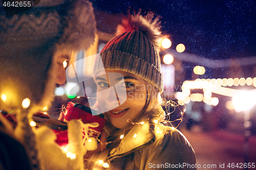 Image of Adult couple hanging out in the city during Christmas time