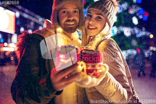 Image of Adult couple hanging out in the city during Christmas time