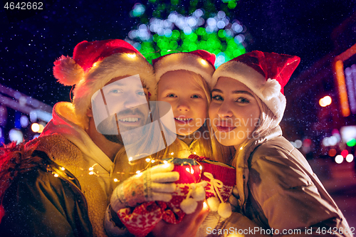 Image of family, christmas, holidays, season and people concept - happy family over city background and snow