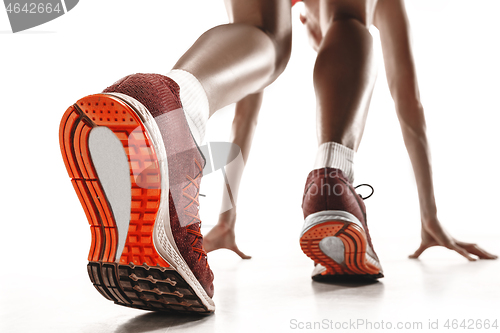 Image of Portrait of young sporty woman at starting block of race isolated over white background