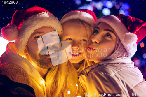 Image of family, christmas, holidays, season and people concept - happy family over city background and snow