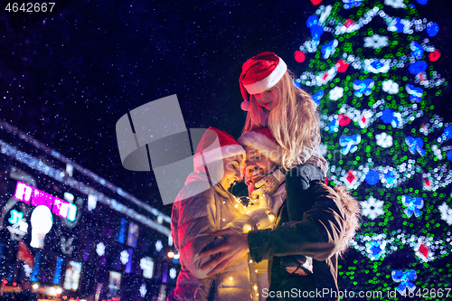 Image of family, christmas, holidays, season and people concept - happy family over city background and snow