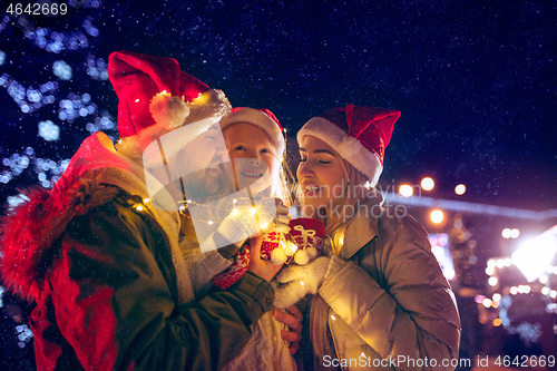 Image of family, christmas, holidays, season and people concept - happy family over city background and snow