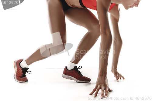 Image of Portrait of young sporty woman at starting block of race isolated over white background