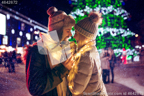 Image of Adult couple hanging out in the city during Christmas time