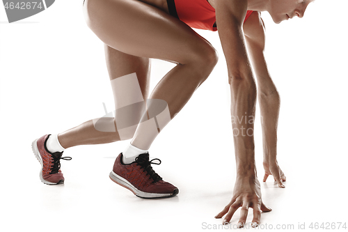 Image of Portrait of young sporty woman at starting block of race isolated over white background