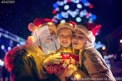 Image of family, christmas, holidays, season and people concept - happy family over city background and snow