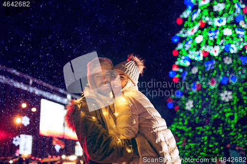 Image of Adult couple hanging out in the city during Christmas time