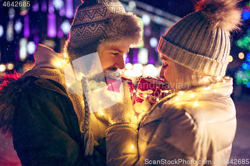Image of Adult couple hanging out in the city during Christmas time