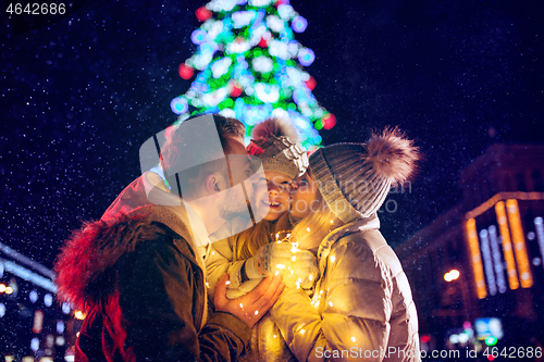 Image of family, christmas, holidays, season and people concept - happy family over city background and snow