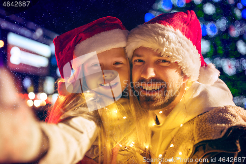 Image of family, christmas, holidays, season and people concept - happy family over city background and snow