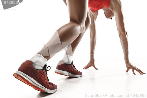 Image of Portrait of young sporty woman at starting block of race isolated over white background