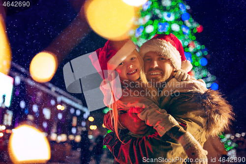 Image of family, christmas, holidays, season and people concept - happy family over city background and snow