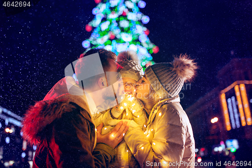 Image of family, christmas, holidays, season and people concept - happy family over city background and snow