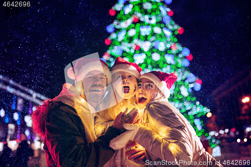 Image of family, christmas, holidays, season and people concept - happy family over city background and snow