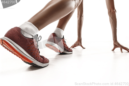 Image of Portrait of young sporty woman at starting block of race isolated over white background