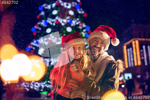 Image of family, christmas, holidays, season and people concept - happy family over city background and snow
