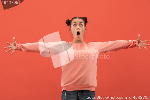 Image of Beautiful woman looking suprised isolated on coral