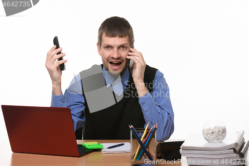 Image of an office worker shouts at one phone and holds the other hand of the second