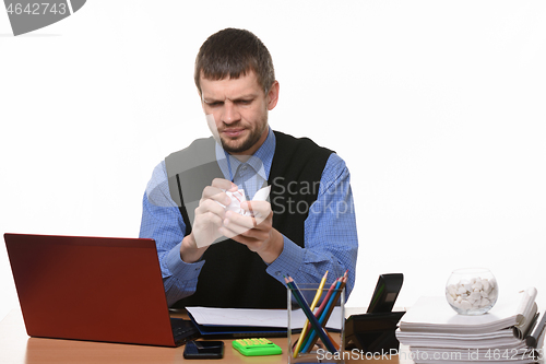 Image of man in the office clumps a piece of paper on a white background