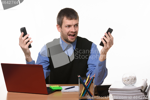 Image of man with two phones in shock looks at them