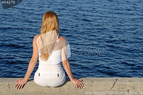 Image of Longhaired girl sitting by the sea