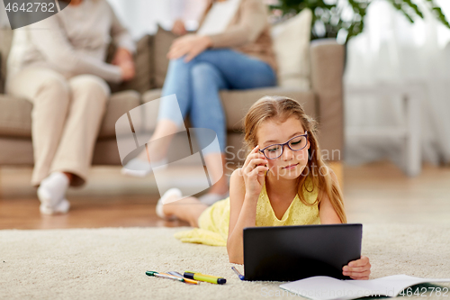 Image of student girl with tablet pc lying on floor at home