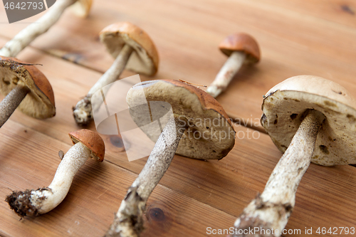 Image of brown cap boletus mushrooms on wooden background