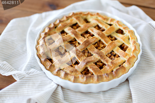 Image of close up of apple pie in mold on wooden table