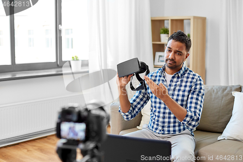 Image of male blogger with vr glasses videoblogging at home