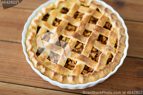 Image of close up of apple pie in mold on wooden table