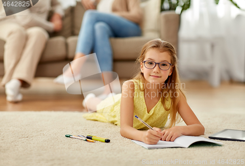 Image of student girl writing to notebook at home