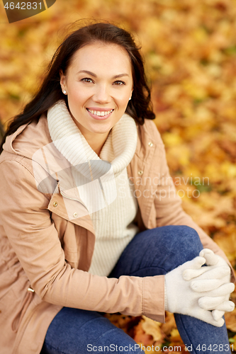 Image of beautiful happy young woman smiling in autumn park