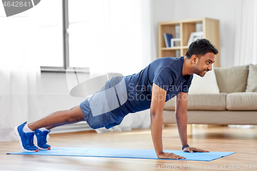 Image of indian man doing push ups at home