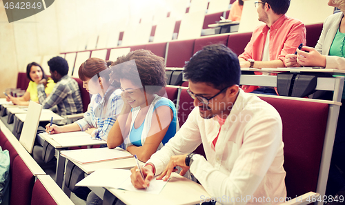 Image of group of students with notebooks in lecture hall