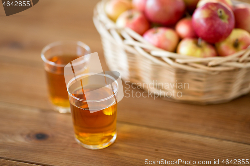 Image of apples in basket and glasses of juice on table